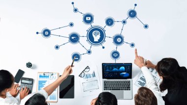 Çeşitli bir ekip, modern bir iş alanında veri görselleştirme ve analizlerinin yer aldığı, yenilikçi stratejileri geliştiren yapay zeka kavramları üzerinde işbirliği yapmaktadır. Dostluk