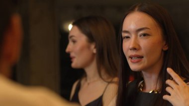 Lüks bir kokteyl barında grup arkadaşıyla gülümseyen güzel bir kadının portresi. Gece kulübünde sosyetik etkileşim için doğal yüz güzelliğini kostüm içinde yakalamak. Vinosity.