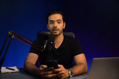 Canlı yayında dinleyiciyle konuşan yayıncı, Mor Neon Işık Stüdyosu 'ndaki yaratıcı pozitif düşünce konseptiyle sosyal medyada akıllı telefondan mesajları kontrol ediyor. Tahmin et..