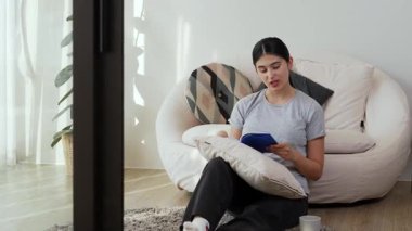 Kanepede oturan orta yaşlı bir kadın, sosyal ve teknolojik mesleki gelişmeler hakkında ders kitabı okur ya da zeki bir anne olmak için çocuk yetiştirir. Hayat boyu öğrenme konsepti. Uyumsuzluk.