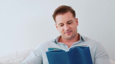 Kanepede oturan orta yaşlı bir adam, sosyal ve teknolojik mesleki gelişmeler hakkında ders kitabı okur ya da çocukları iyi bir yetişkin baba olmak için yetiştirir. Hayat boyu öğrenme konsepti. Uyumsuzluk.