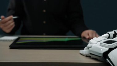 Bir danışman, pazarlama planlarını ve iş projeksiyonlarını modern, teknolojik geliştirilmiş bir ofis alanında optimize etmek için veri güdümlü stratejiler kullanarak yapay zeka kavrayışlarını entegre eder. Noogenesis Yapay Zeka