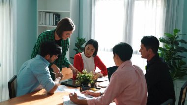 İş kadını yürüyor ve bir grup yatırımcıya pazarlama planını sunmak için tablet tutuyor. Finansal grafik ve selamlama projesi yöneticisine el sallama hakkında tartışan yaratıcı bir başlangıç ekibi. Cemaat.