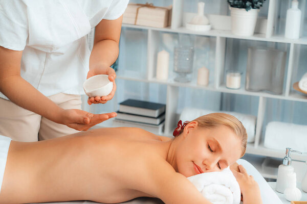 Массажист выливает ароматное масло на спину женщине. Массажист готовит масляный массаж для клиента в спа-салоне на роскошном курорте. Концепция массажа тела с ароматическим маслом. Quiescent