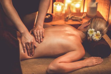 Beyaz kadın müşteri stres önleyici spa masajının keyfini çıkarıyor ve lüks otel ya da otelde sıcak mum ışığında güzellik teniyle eğleniyor. Sessiz.