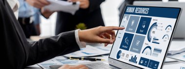 İş zekası ve veri analizi kavramı. Analizci ekibi laptop ekranında finansal veri analizi üzerinde çalışıyor. Etkili iş stratejik planlama için pazarlama göstergesi olarak. İçgörü