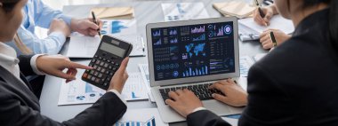 İş zekası ve veri analizi kavramı. Analizci ekibi laptop ekranında finansal veri analizi üzerinde çalışıyor. Etkili iş stratejik planlama için pazarlama göstergesi olarak. İçgörü