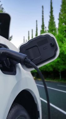 Elektrikli araç konsepti, yeşil çevre için yenilenebilir ve temiz enerjiyle çalışan EV otomobilinin varış noktasına ulaşmadan önce ormandaki şarj istasyonunun enerjisini şarj etmek için durur..