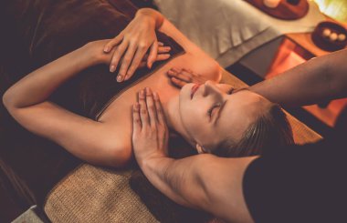 Beyaz kadın müşteri stres önleyici spa masajının keyfini çıkarıyor ve lüks otel ya da otelde sıcak mum ışığında güzellik teniyle eğleniyor. Sessiz.