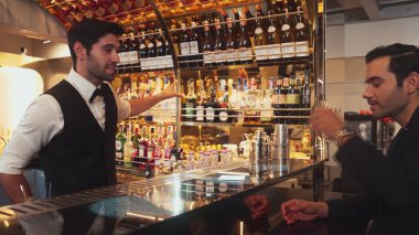 Akıllı barmen, lüks bir tezgahta arkadaşını beklerken limonlu cin kokteyli ikram ediyor. Barmen, canlı gece hayatı parti atmosferinde mükemmel hizmet veriyor. Vinosity.