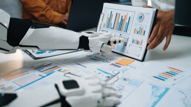 Gelecekçi bir robot asistan veri analizi yapıyor, modern ofis ortamında çeşitli grafik ve grafikler sergiliyor, takım çalışmasındaki teknolojik gelişmeleri vurguluyor.