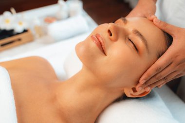 Kafkasyalı kadın stres önleyici kafa masajından ve lüks tatil beldesi ya da otel spa salonundaki modern ışık ortamında yüz güzelliği eğlencelerini şımartmaktan hoşlanıyor. Sessiz.