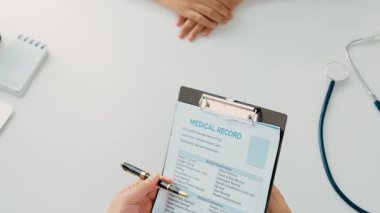 Klinikteki ya da hastane ofisindeki doktor randevusuna katılan hasta, tıbbi tedavi seçeneklerini tartışıyor ve muayene sonuçlarını ya da hastalıkla ilgili tıbbi kayıtları açıklıyor. Ağır çekim. Katı.