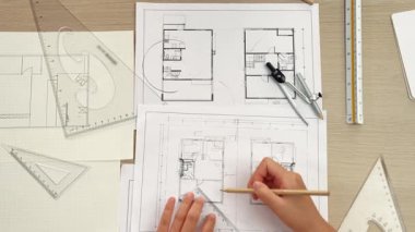 Akıllı mimar ya da akıllı mühendisin ölçüm aracı ve kalem el kullanarak mimari ofisindeki inşaat isabet planı üzerine detaylı bir yazı yazışının videosu. Eline odaklan. - Yakın çekim. Tanımlama.