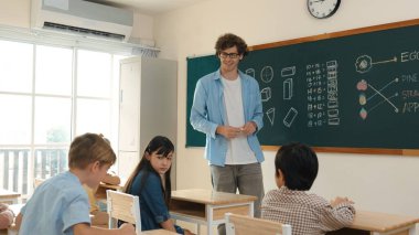 Kafkas öğretmeni matematik dersinde tahtaya cevap yazmak için gönüllü buldu. Öğretmen, öğrenciye tebeşir verilirken ve sınıfın önünde yürürken soruyu cevaplamak için gönüllü olmayı talep ediyor. Pedagoji.