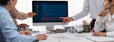 İç mimar tasarımcı grubu, daha kesin tasarım için planlar ve dizüstü bilgisayar ekran mimari yazılımı üzerinde birlikte tartışıyorlar. Modern ev tasarımı ve yenileme. İçgörü