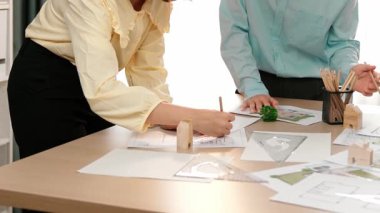 Mimarın bir videosu, şablonu ölçmek için ölçüm aletleri ve kalem kullanır. Mimar tasarım evi inşaatı stüdyoda bir masanın üzerinde, mimari plan etrafa saçılmış. Odaklan. Tanımlama.