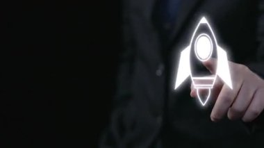 Bu resimde, yenilik ve büyümeyi vurgulayan, iş ve teknolojiyi temsil eden çeşitli sembollerle çevrili fütüristik bir roket fırlatma ikonu yer alıyor. Dörtgen