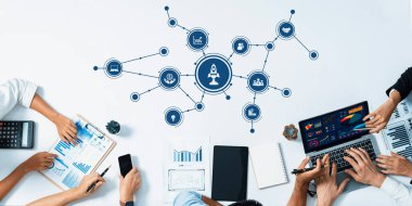 Veri analizi ve stratejiler konusunda işbirliği yapan profesyonellerin yer aldığı dinamik bir iş toplantısı. Kurumsal bir çalışma alanında takım çalışması ve yenilik vurgulanıyor. Dostluk