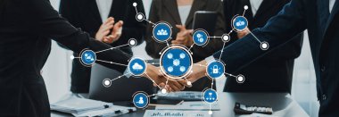 Bu resim, kurumsal bir ortamda modern takım çalışmalarını vurgulayarak, bağlantıları ve ortaklıkları temsil eden bir el sıkışma ve dijital simgelerle bir iş birliği sahnesi sergiliyor. Dostluk