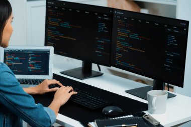 İnternet sitesi uygulamasının kodlama verileriyle birlikte online bilgi yazarak kot gömlek giyen genç Asyalı geliştirici. Güvenlik analizi ile çevrili iki ekran. Taktik.