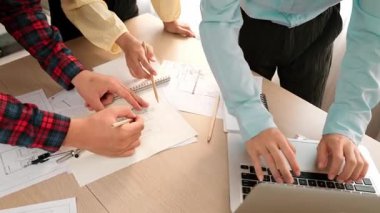 Mimarlık ve güvenlik mühendisi, modern ofiste doğruluk için mimari belge ve ölçüm aracı kullanılarak dizüstü bilgisayarın üzerinde sergilenen planlar hakkında tartıştı. - Yakın çekim. Tanımlama.