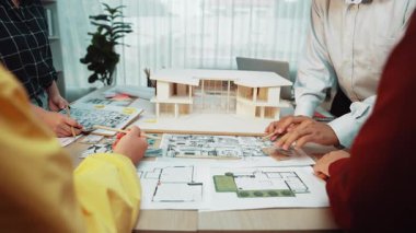 Bir grup mimari profesyoneli, parlak modern bir ofiste plan ve tasarım planlarını analiz ederek takım çalışması ve yaratıcılık sergileyen bir ortak atölyeye katılıyorlar. SACTR