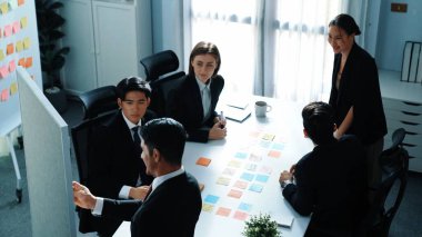 Akıllı iş adamlarının toplantı odasında pazarlama ekibinin yaratıcı fikirlerini anlatırken tahtaya yapışkan notlar yapıştırdığı en iyi manzara. Lider, başlangıç projesini çeşitli yatırımcılara açıkladı. Müdürlük.