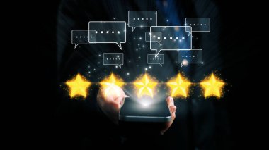 Bir kullanıcı akıllı bir telefon tutuyor, parlayan yıldızlar ve sohbet baloncukları gösteriyor, dijital geri bildirim ve modern teknolojiyle bağlantıyı sembolize ediyor, çevrimiçi etkileşimi geliştiriyor. Dörtgen