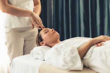 Kafkasyalı kadın stres önleyici kafa masajından ve lüks tatil beldesi ya da otel spa salonundaki modern ışık ortamında yüz güzelliği eğlencelerini şımartmaktan hoşlanıyor. Sessiz.