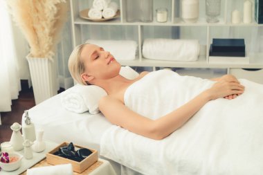 Kafkasyalı kadın müşteri stres önleyici spa masajının keyfini çıkarıyor ve lüks otel ya da oteldeki gündüz açık ortam güzellik salonunda güzellik teniyle eğleniyor. Sessiz.