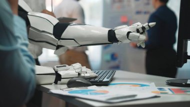 Gelecekçi bir robotik kol modern bir ofiste bir bilgisayar klavyesiyle etkileşime girer ve profesyonel bir ortamda teknolojinin ve insan işbirliğinin entegrasyonunu vurgular. Noogenesis