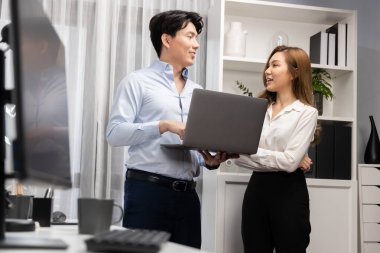 Gülümseyen Asyalı iş arkadaşları modern ofiste dizüstü bilgisayar pazarlama projesi hakkında konuşurken. Yeni sosyal medya kanalında başarılı müşteri ihtiyaçları analiz ediliyor. İnfobahn.