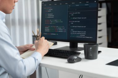 Çevrimiçi web sitesinin bilgisayar ekranında kodlama programı uygulamasına bakan akıllı bilişim geliştiricisi, modern ofisteki iş dünyası pazarında akıllı veritabanı geliştirme sistemini analiz ediyor. İnfobahn.