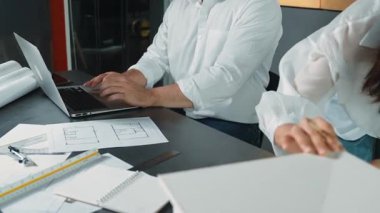 Bir grup mimar mühendis birlikte çalışıyor ve ofis tasarımı hakkında tartışıyorlar. Genç mühendis ev modelini ölçerken yönetici dizüstü bilgisayar kullanıyor. İş tasarımı konsepti. Yönlendirici.