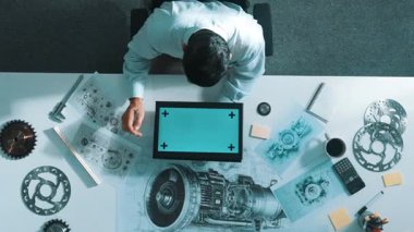Türbin motor çizim tasarımı, metal teçhizat ve mimari ekipmanlar etrafa saçılmış yeşil ekranı incelerken kağıt üzerine yazı yazan yetenekli mühendisin üst görünümü. Hizalama.
