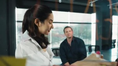 Genç kendine güvenen iş kadını projeyi uzman yatırımcıya sundu. Profesyonel proje yöneticisi başlangıç projesini açıklamak için yapışkan notlar kullanır, beyin fırtınası fikirlerini yatırımcıya paylaşır. Yönlendirici.