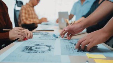 Profesyonellerden oluşan çeşitli bir ekip, plan ve çizimler üzerindeki mimari tasarımları analiz ederek, yaratıcılığı ve işbirliğini teşvik ederek beyin fırtınası yapıyor. SACTR