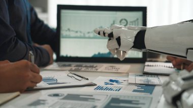 Modern bir ofiste insanlarla işbirliği yapan bir robot, veri analizine odaklanıyor. Grafiksel temsiller ve grafikler iş ortamlarında takım çalışmasını ve yeniliği simgeler. Noogenesis