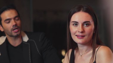 Barda ciddi suratlı akıllı telefonlara bakarken çift ile konuşan güzel bir kadının portresi. Gece kulübünde sosyal etkileşimi giydirip doğal yüz güzelliğini yakalamak. Vinosity.