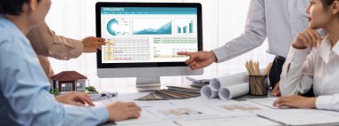 İç mimar tasarımcı grubu, daha kesin tasarım için planlar ve dizüstü bilgisayar ekran mimari yazılımı üzerinde birlikte tartışıyorlar. Modern ev tasarımı ve yenileme. İçgörü