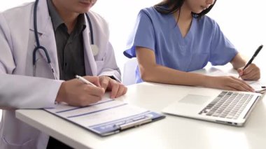 Hastane masasında birlikte çalışan ve tıbbi tedavi planlayan çeşitli profesyonel sağlık görevlileri. Takım çalışması başarılı hastalıklara ve hastalıklara yol açar. Ağır çekim. Katı.