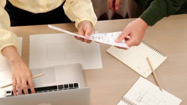 Akıllı mimar ve akıllı mühendisin dizüstü bilgisayarlı videosu mimarlık bürosundaki inşaat isabet planı hakkında tartışıyorlar. Eline odaklan. - Yakın çekim. Tanımlama.