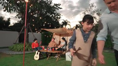 Aile birlikte bahçede kamp kurar, baba ve kız aile bireyleri için ızgara yapar. Doğayla iç içe olmak için açık hava kamp aktiviteleri ve genç nesil çapraz kuşaklarla zaman geçirmek için. Uyumsuzluk.