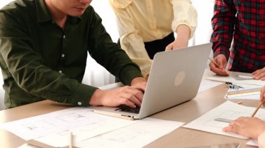 Masada dizüstü bilgisayarda ayrıntılı tasarım görüntüsünü izleyen mimar ve güvenlik mühendisi, diğer bir tasarımcı yazım planı modern ofiste doğruluk için ölçüm aracı kullanıyor. - Yakın çekim. Tanımlama.