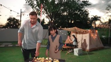Aile birlikte bahçede kamp kurar, baba ve kız aile bireyleri için ızgara yapar. Doğayla iç içe olmak için açık hava kamp aktiviteleri ve genç nesil çapraz kuşaklarla zaman geçirmek için. Uyumsuzluk.