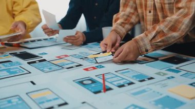 Profesyonellerden oluşan çeşitli bir ekip, dijital prototipleri analiz ederek ve modern ofis ortamında stratejileri tartışarak, işbirlikçi bir kullanıcı arayüzü tasarım oturumuna girişir. SACTR