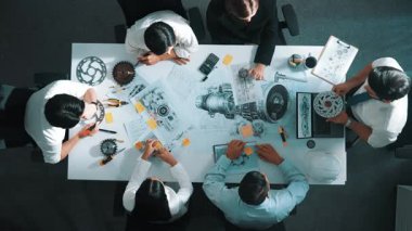 Mühendisin, toplantı masasındaki türbin motorunu ekipmanla gösteren üst düzey görüntüsü. Profesyonel proje yöneticisinin elektronik jeneratör sistemi hakkında konuştuğu ve tartıştığı hava görüntüsü. Hizalama.