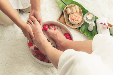 Kadınlar lüks spa salonlarında keyifli ayak masajlarına devam ederken, masör de hafif gün ışığı atmosferinde refleksoloji terapisi veya otel ayak spa 'sında. Sessiz.