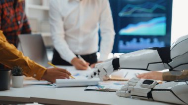 İş büyümesi için yenilikçi teknoloji ve veri analizini vurgulayan, insan işçiler ve robotik kol arasındaki işbirliğini gösteren fütüristik ofis sahnesi. Noogenesis